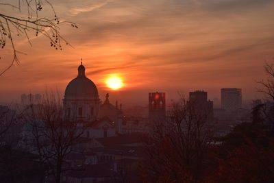 Panoramic view of buildings and trees against sky during sunset