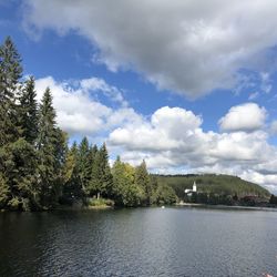 Scenic view of river by trees against sky