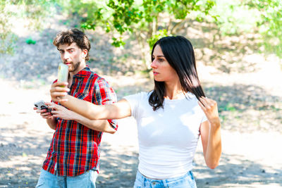 Young couple holding smart phone outdoors