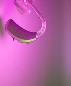 Close-up of illuminated lamp against pink background