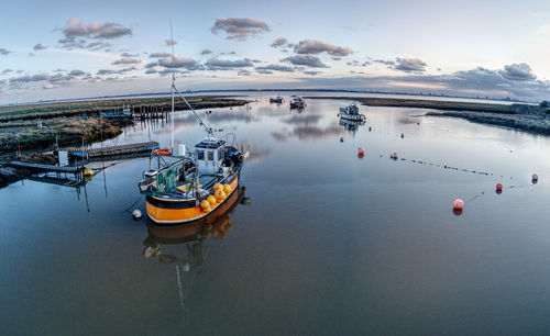 High angle view of sailboats moored in sea against sky