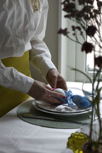 Mid section of woman preparing easter place setting