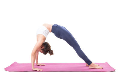 Full length of woman exercising against white background