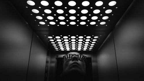Woman with sunglasses inside an elevator with lights