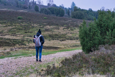 Rear view of people on street amidst trees