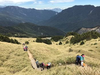 People on field against mountains