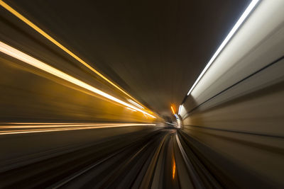 Light trails on railroad tracks in tunnel