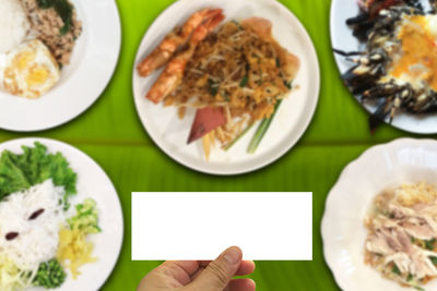 Close-up of hand holding food in plate