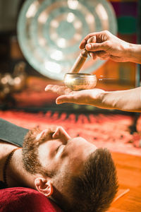 Therapist playing rin gong while performing music therapy at spa