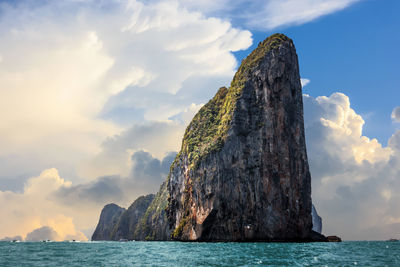 Rock formation in sea against sky