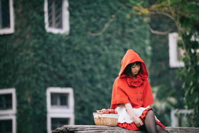 Woman wearing hat standing against plants