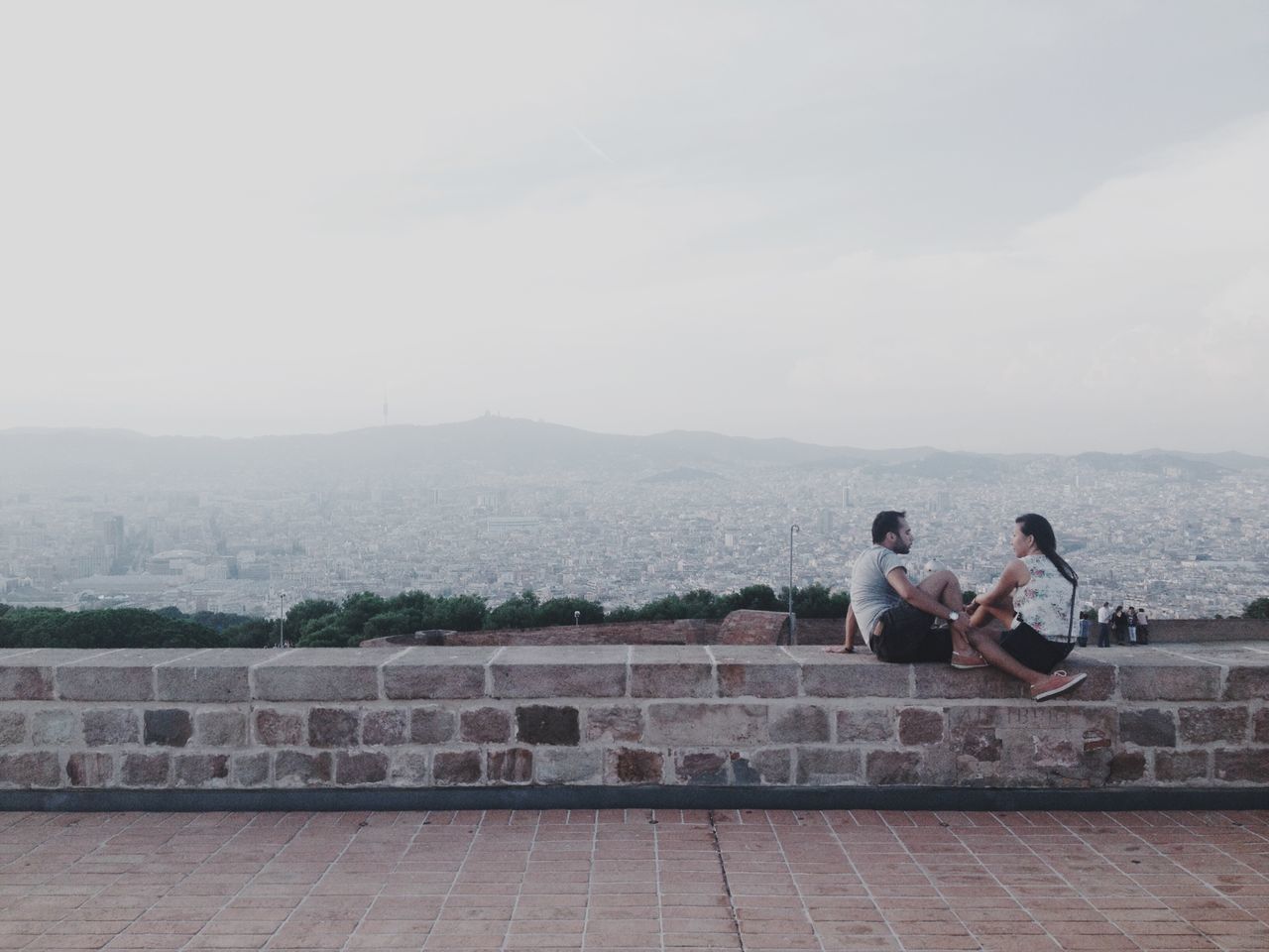 lifestyles, leisure activity, sky, building exterior, full length, sitting, built structure, architecture, casual clothing, men, rear view, person, day, mountain, young adult, cloud - sky, outdoors