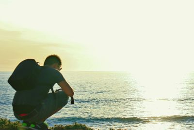 Rear view of couple standing at sea shore during sunset