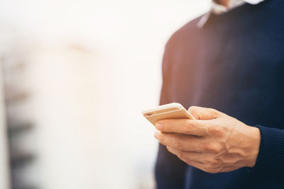 Midsection of man using mobile phone