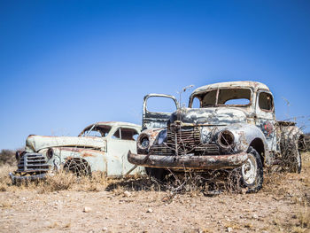 Abandoned cars against sky