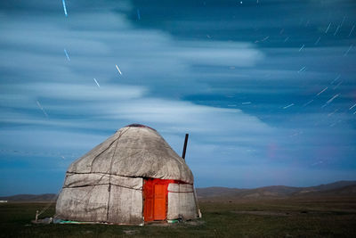 Yurt on field against sky at dusk