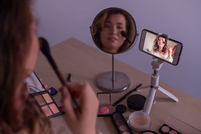 Woman photographing with smart phone on table