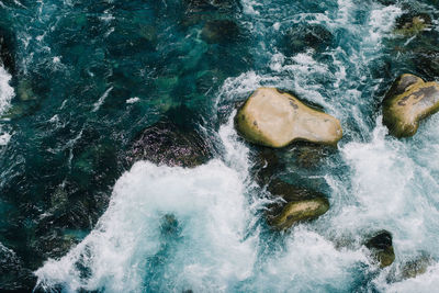 High angle view of waves splashing on rocks