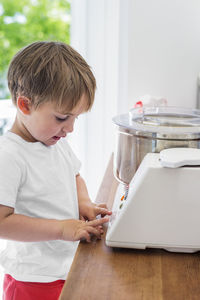 Boy looking at food processor in kitchen