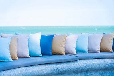 Row of multi colored deck chairs against blue sky