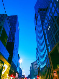 Low angle view of modern buildings against clear blue sky