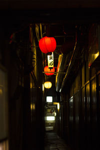 Illuminated lanterns hanging in building at night