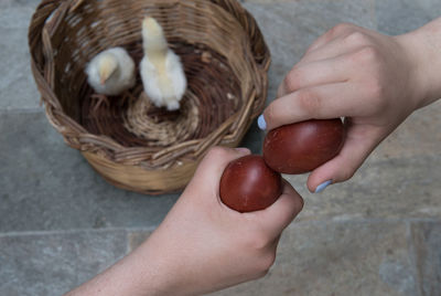 Teenage girls holding and cracking red easter eggs.