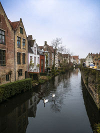 Canal amidst buildings against sky