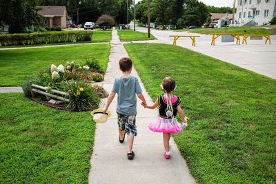 Brother and sister walking on footpath 