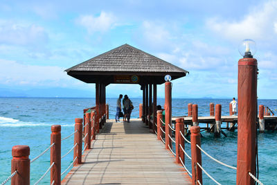 Rear view of pier over sea against sky