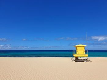 Lifeguard hut on beach against sky