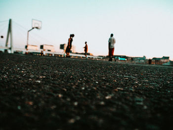 People standing on street against clear sky