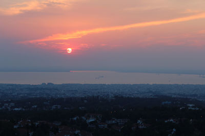 Aerial view of cityscape against sky at sunset