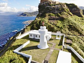 Traditional building by sea against sky