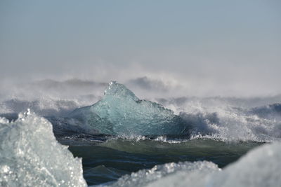 Water splashing in sea against sky