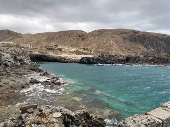 Scenic view of sea and mountains against sky