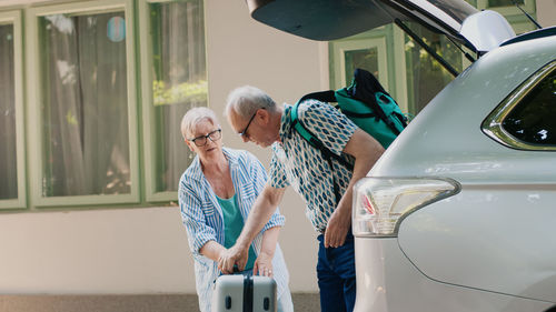 Side view of man holding car