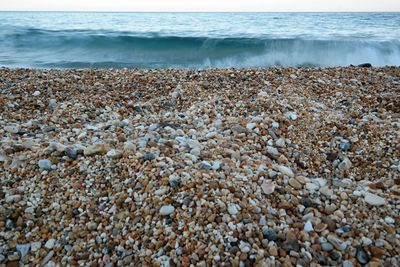 View of pebbles on beach against sky