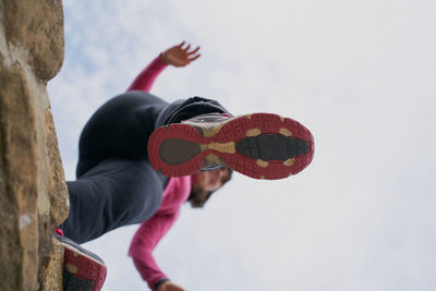 Unrecognizable woman jumping from wall