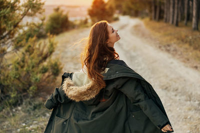 Woman with arms raised standing on land