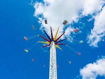 Low angle view of chain swing ride against sky