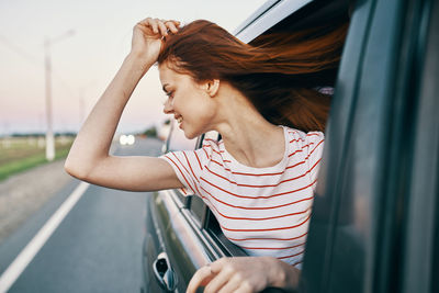 Cheerful woman leaning out of car