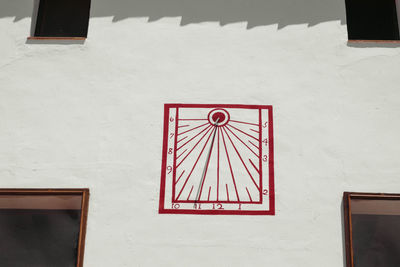 Close-up of red umbrella against white wall