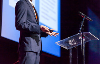 Midsection of man giving presentation at podium