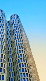 Low angle view of modern building against blue sky