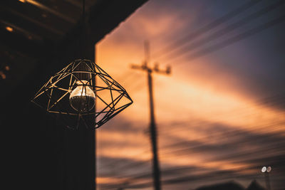 Low angle view of silhouette crane against sky during sunset