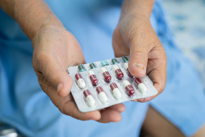 Midsection of man holding dentures