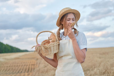 Midsection of woman wearing hat while standing on wicker basket