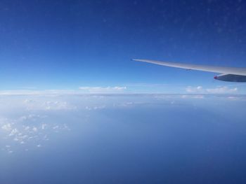 Cropped image of airplane flying over clouds