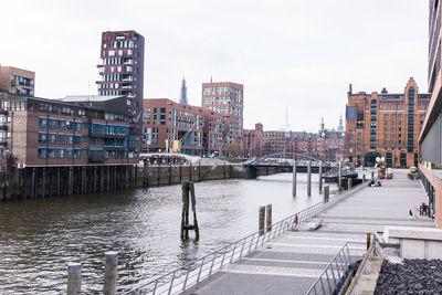 River canal amidst buildings in city against sky